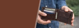 Brown bifold leather wallet held open showing cash and cards – Leather and Kid
