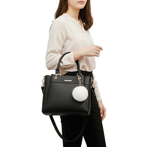 Leather and Kids black leather handbag with white pom-pom charm worn on model's shoulde