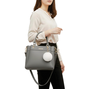 Leather and Kids grey leather handbag with white pom-pom charm worn on model's shoulder