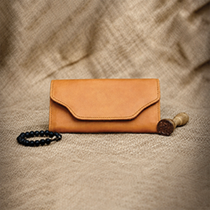 Tan Leather Envelope Wallet with Beaded Wristlet in a tan wallet standing front display against a draped fabric backdrop.